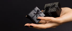 Dos pequeñas cajas de regalo sobre la palma de una persona.