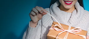 Una mujer abriendo un regalo.