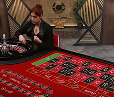 La crupier hace girar la rueda en el casino en vivo.