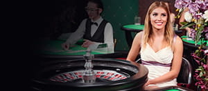 Una crupier sentada ante una ruleta.