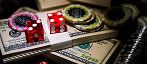 Dos fajos de dólares americanos con fichas de blackjack, juego disponible en nuevos casinos online de España.