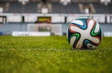 Un balón de fútbol en el césped de un estadio.