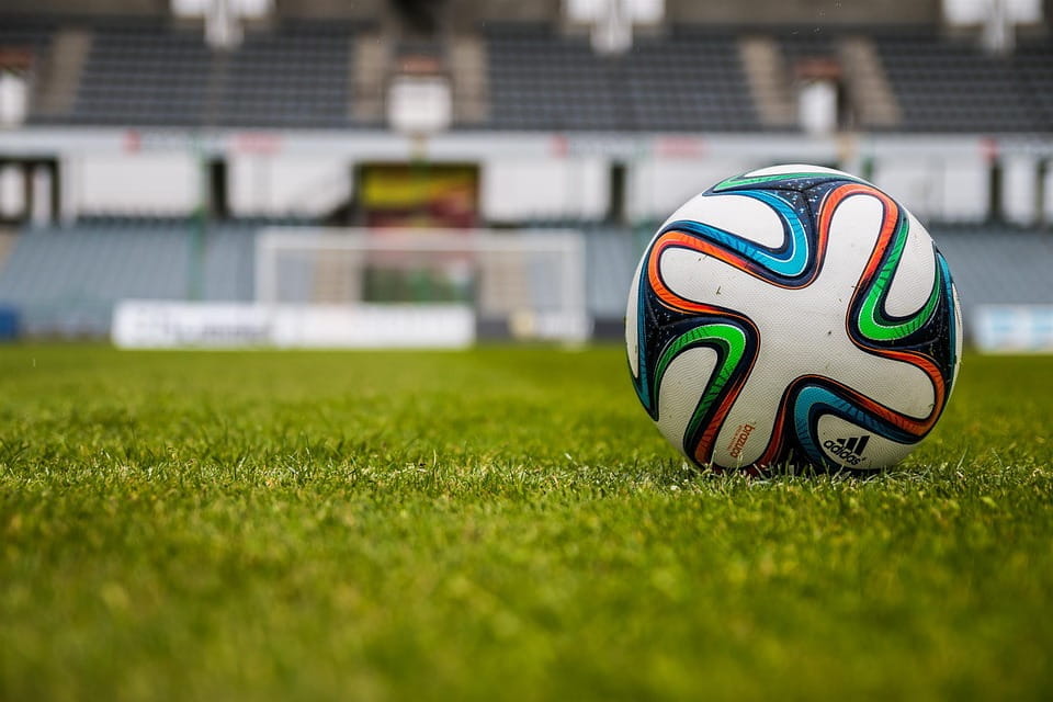 Un balón de fútbol en el césped de un estadio.