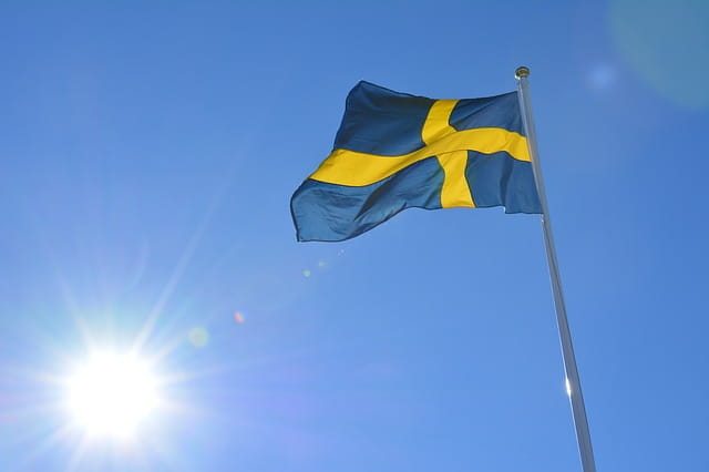 Una bandera de Suecia ondea en lo alto de un poste.