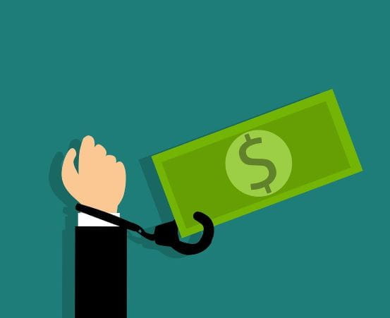 Una mano está esposada al símbolo del dólar.