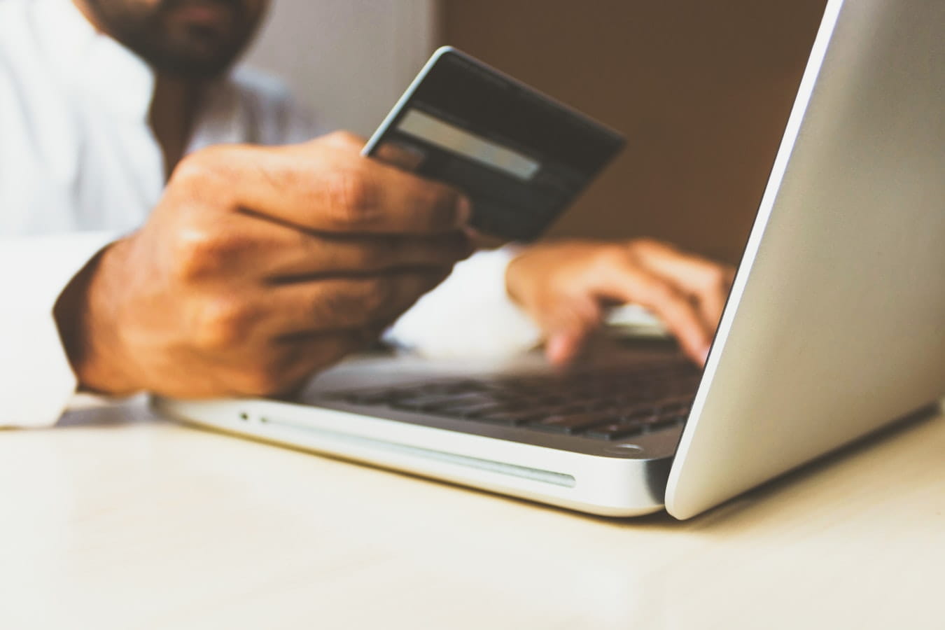 Un hombre comprando por internet con una tarjeta bancaria.