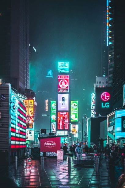 Rótulos de publicidad luminosos en una calle de noche.