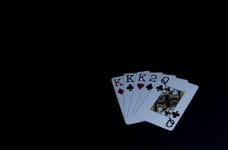 Cartas de póker sobre un paño negro oscuro.
