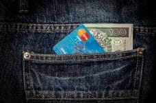 Tarjeta de crédito Mastercard saliendo del bolsillo trasero del pantalón.