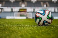 Un balón de fútbol en el césped de un estadio.