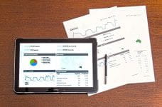 Análisis de marketing sobre una mesa y en la pantalla de una tableta.