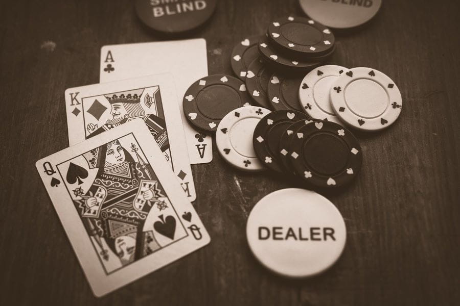 Algunas cartas de la baraja de póker y fichas sobre una mesa.