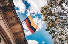 Una bandera de Colombia ondeando sobre un tejado.