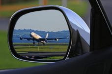 Avión despegando visto desde un espejo retrovisor.