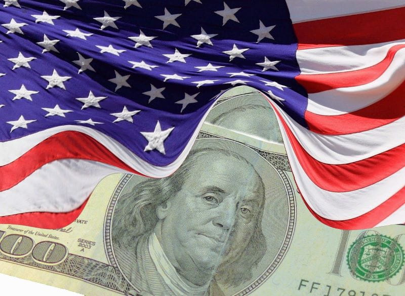 Bendera Amerika menutupi uang dolar.