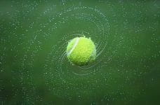 Pelota de tenis girando en el aire.