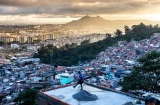 Chutando un balón de fútbol encima de un tejado en una favela en Brasil.