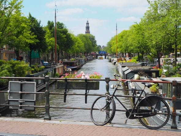 Bicicleta mirando hacia un típico canal en Amsterdam, Holanda.