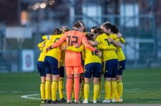 Equipo de fútbol femenino haciendo piña.