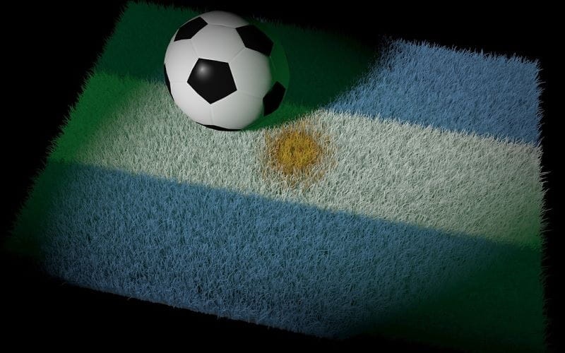 Pelota de fútbol sobre una alfombra con diseño de la bandera de Argentina.