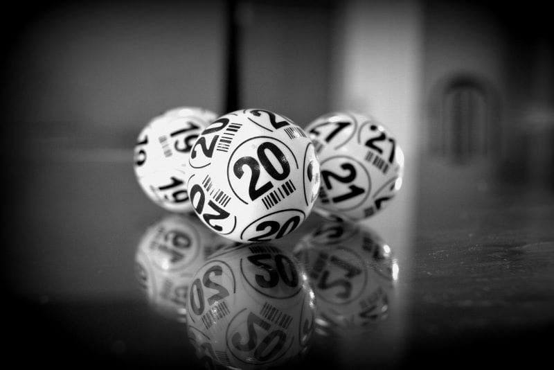 Tres bolas de lotería con los números 19, 20 y 21 sobre un fondo oscuro.