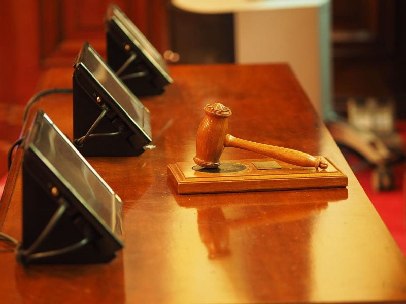 Martillo de madera sobre mesa de un tribunal.