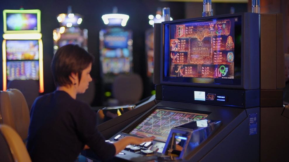 Una mujer juega a una máquina tragaperras en un casino.