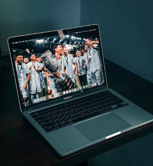 Ordenador portátil en el que se puede ver a el jugador argentino de fútbol Messi sosteniendo una copa.