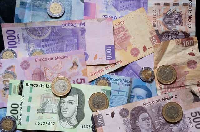Muchas monedas y billetes de pesos mexicanos.