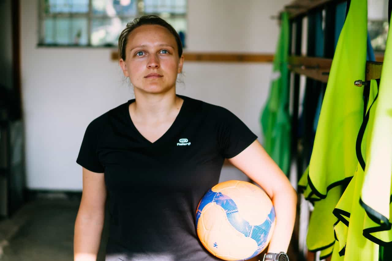 Mujer futbolista en los vestuarios de un campo de fútbol. 