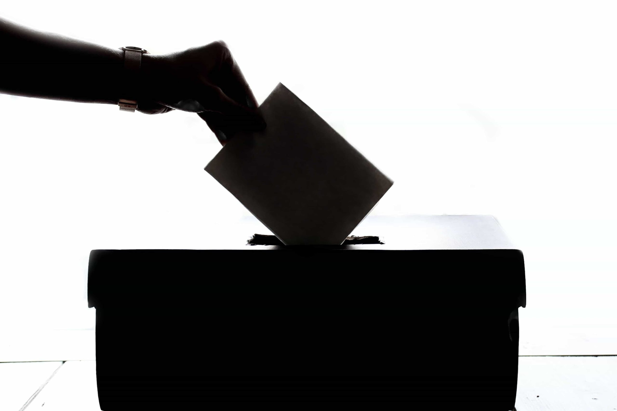 Persona metiendo un voto en una caja.