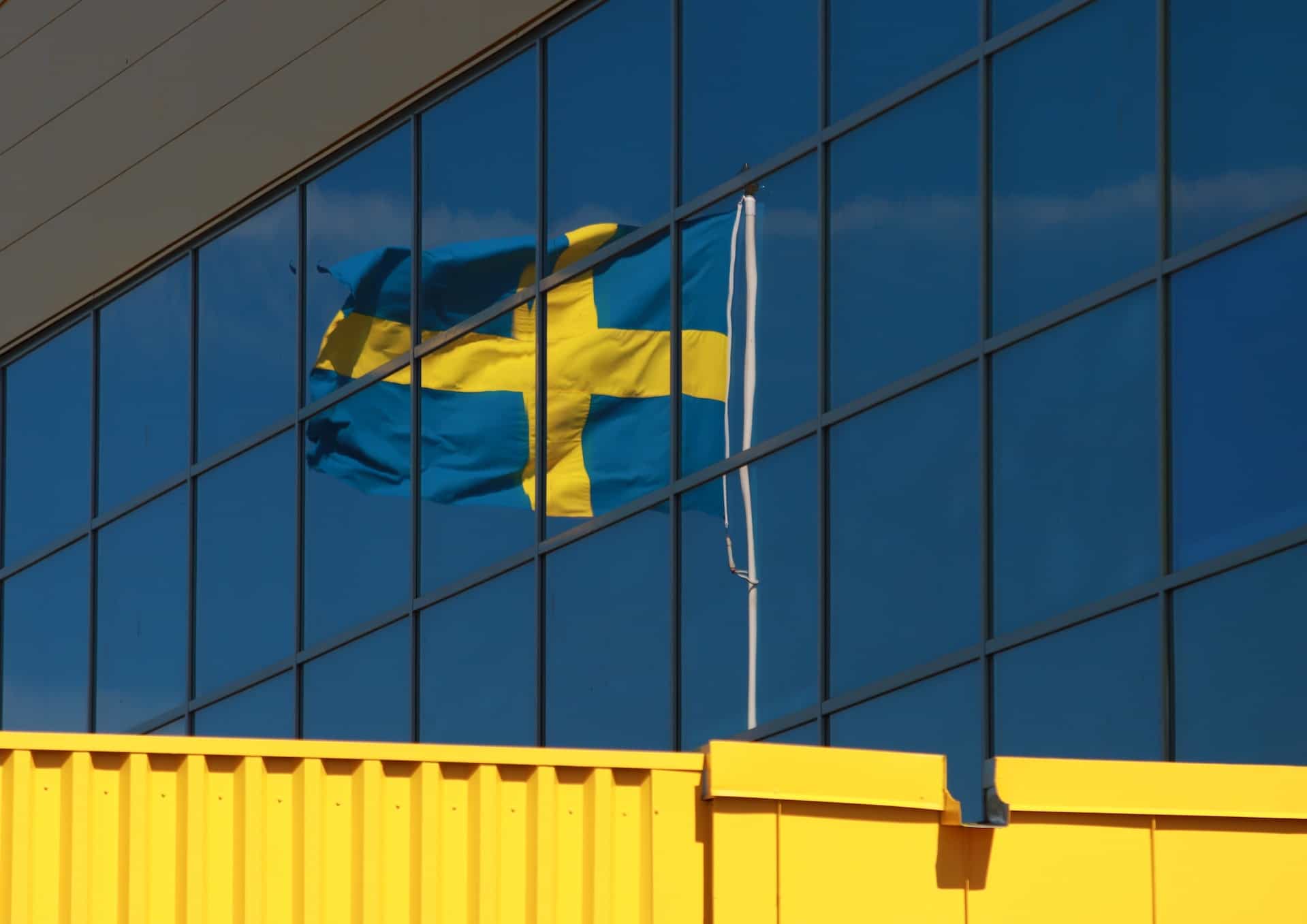 Bandera Suecia reflejada en un edificio.