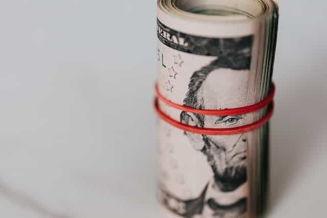 Fajo de billetes enrollado y sujeto con una goma.