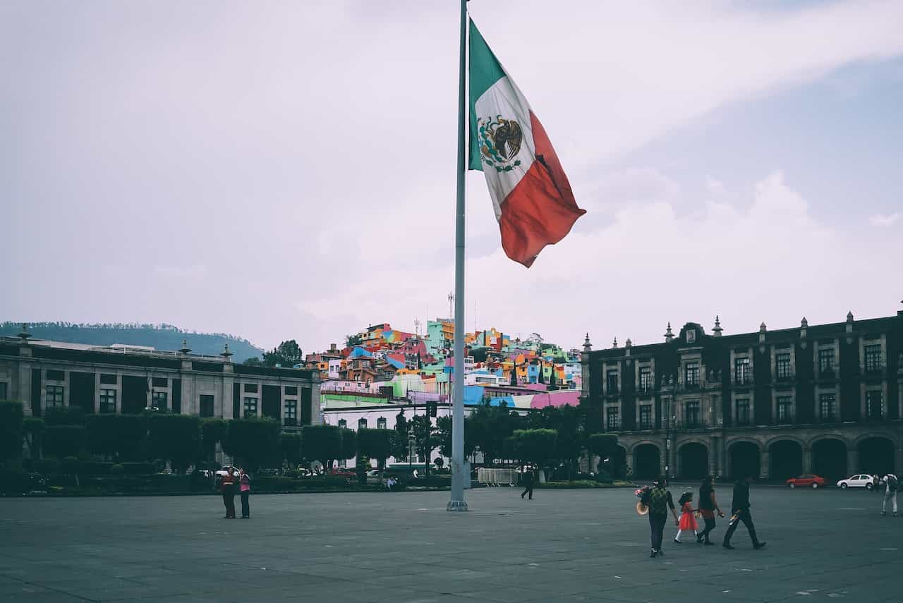 Bandera mexicana en el centro de una plaza.