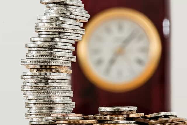 Monedas apiladas junto a otras esparcidas.