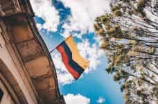Bandera de Colombia ondeando en la fachada de un edificio.