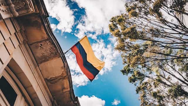 Bandera de Colombia ondeando en la fachada de un edificio.
