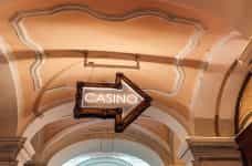 Cartel luminoso con forma de flecha y la palabra casino.