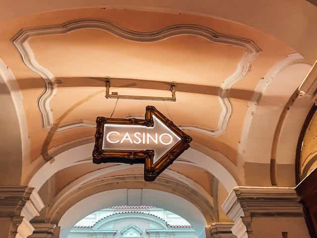 Cartel luminoso con forma de flecha y la palabra casino.