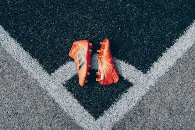 Botas de futbolista sobre el césped del campo.