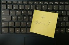 Teclado de un ordenador con un post-it encima en el que se lee I quit, dimito.