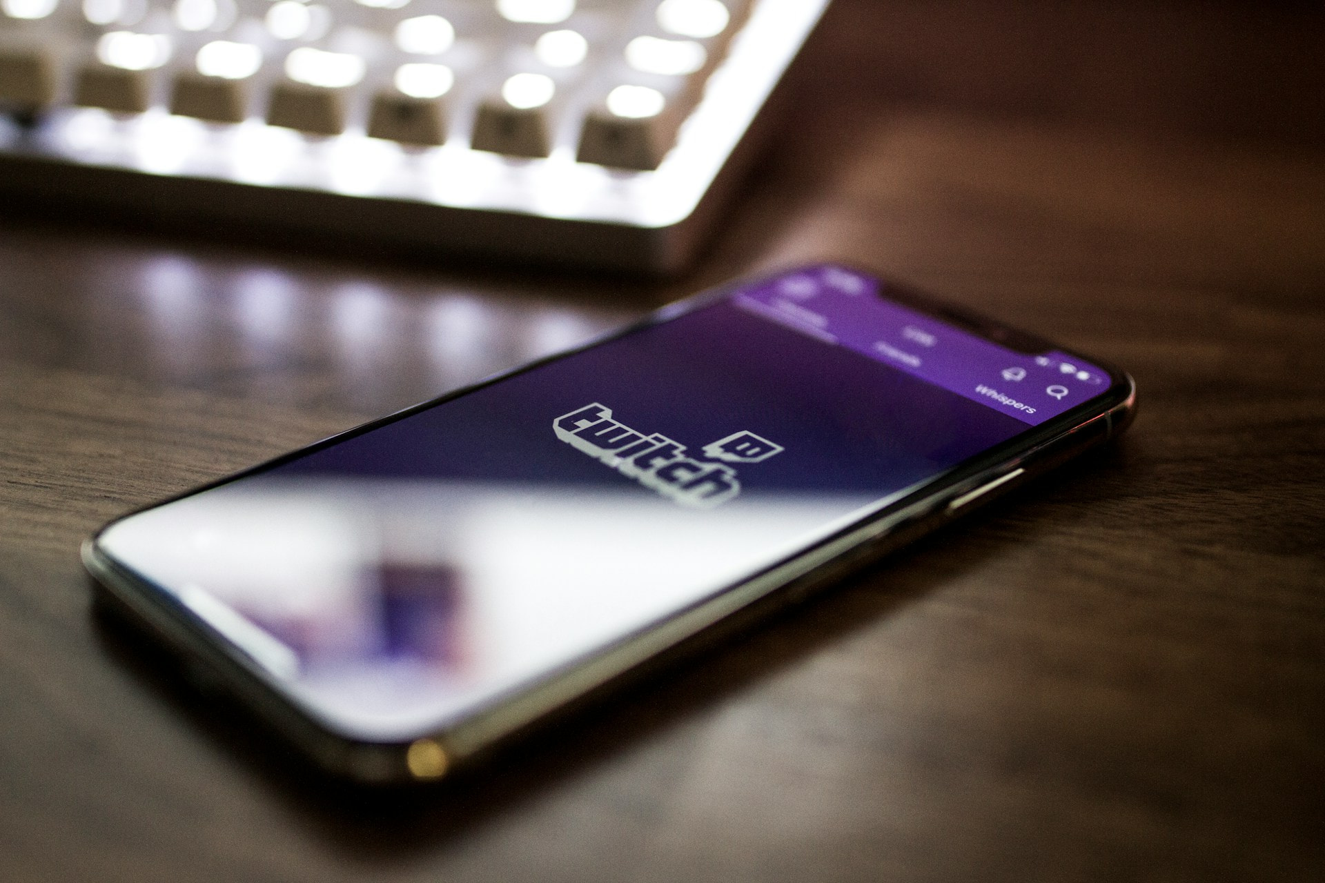 Móvil con la App de Twitch sobre un escritorio.