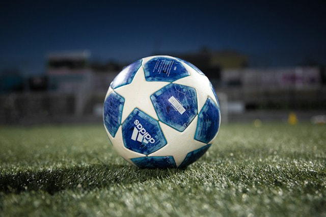Balón de fúbtol sobre el cesped de un campo.