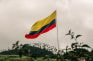 Bandera de Colombia ondeando en la cima de una colina.