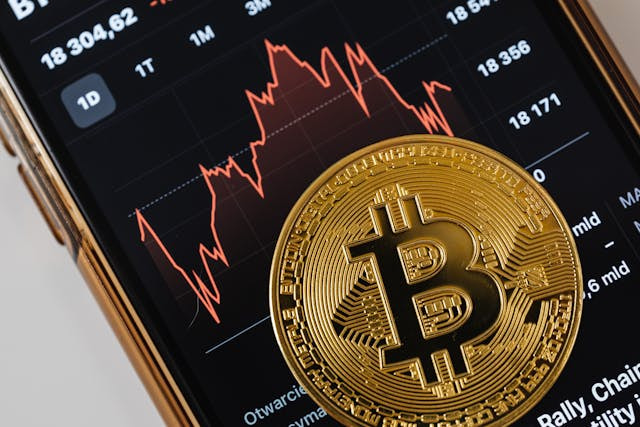 Moneda bitcoin sobre la pantalla de un smartphone.