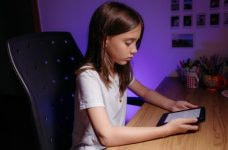 Niña sentada en un escritorio con una tableta.