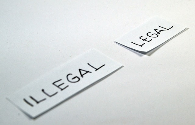 Dos folios doblados por la mital con las palabras ilegal y legal, respectivamente.