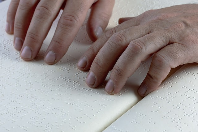 Manos de una persona que está leyendo en braille.