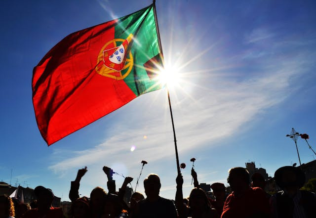 Bandera de Portugal sostenida por un grupo de personas.