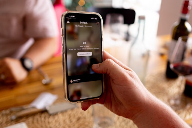 Mano sosteniendo un teléfono móvil con la pantalla bloqueada por una App.